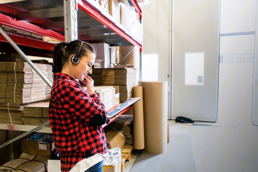 woman with headset and tablet in warehouse